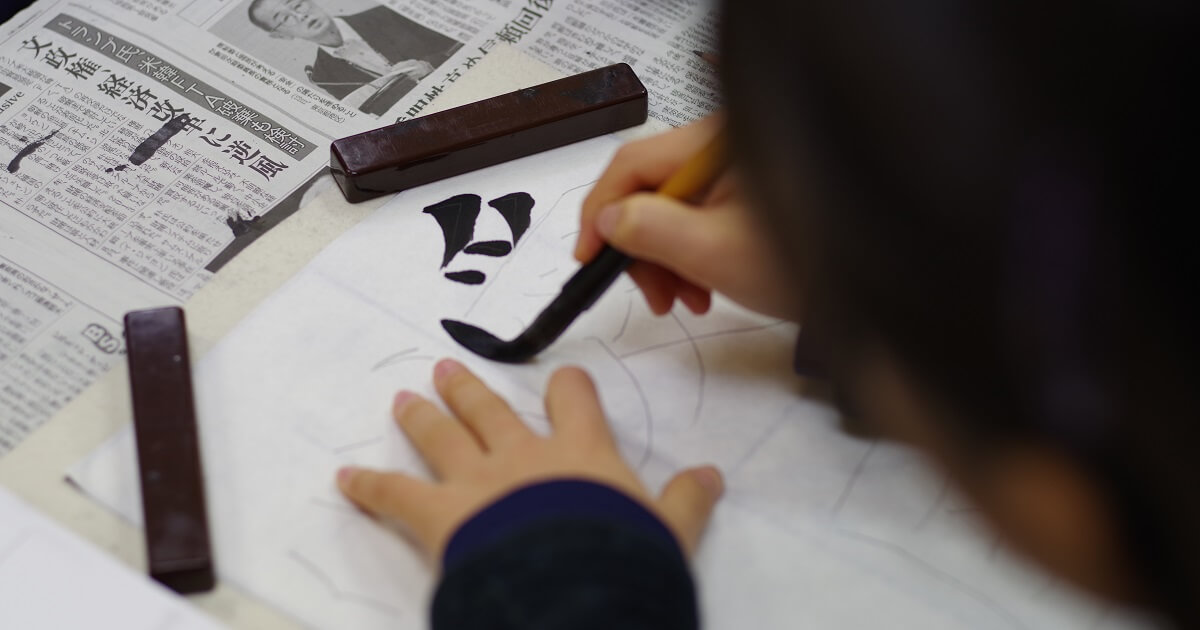 「愛」という字を書いている子ども